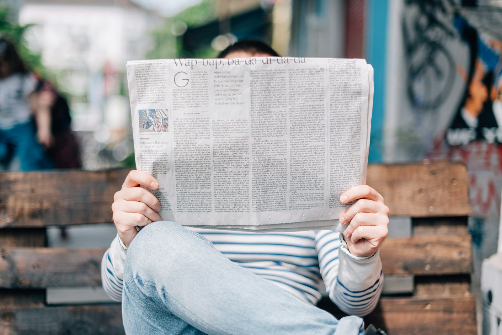 Photo by Roman Kraft man sitting on bench reading newspaper